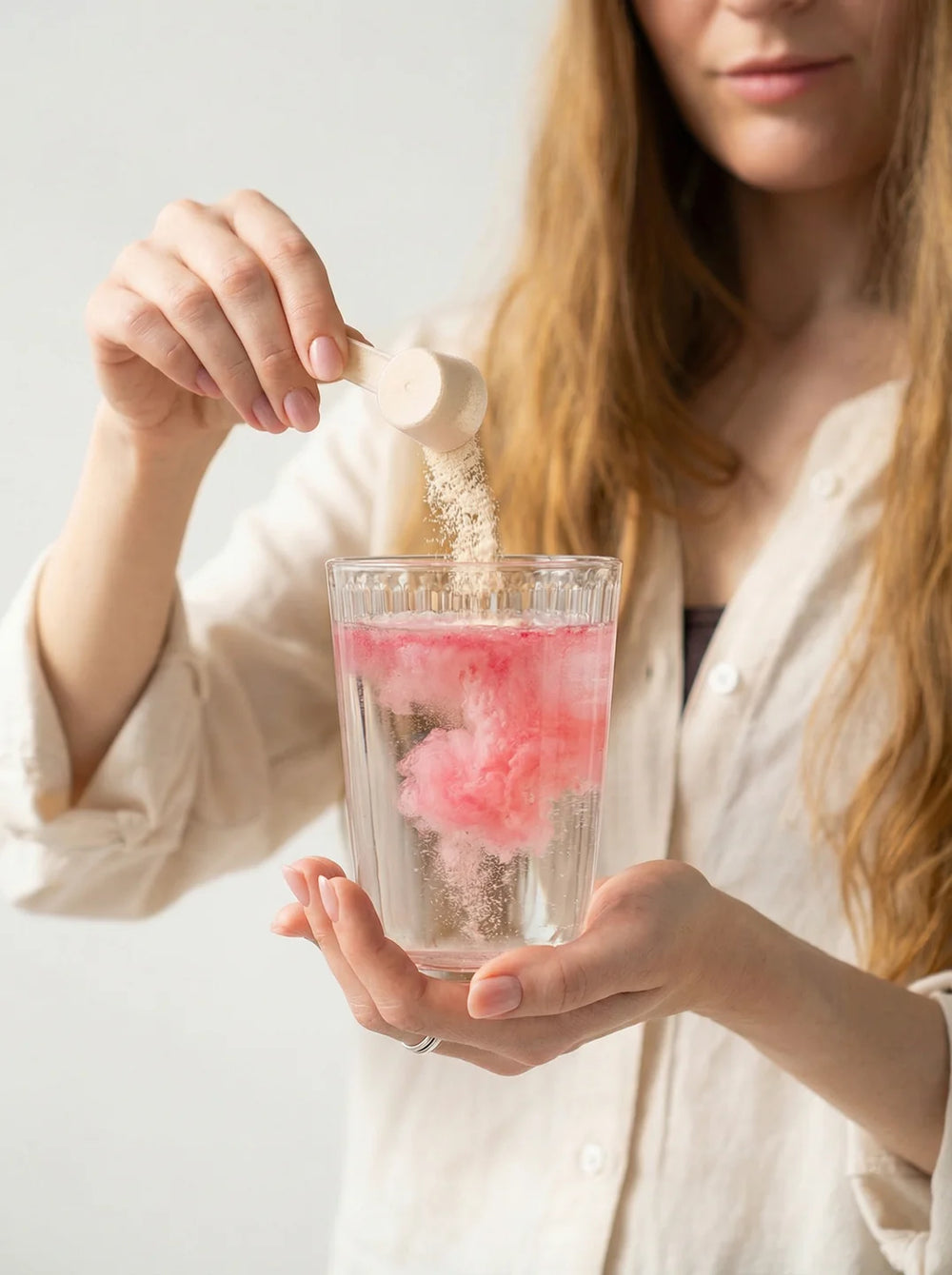 Woman dissolving myo-inositol powder into a glass of water